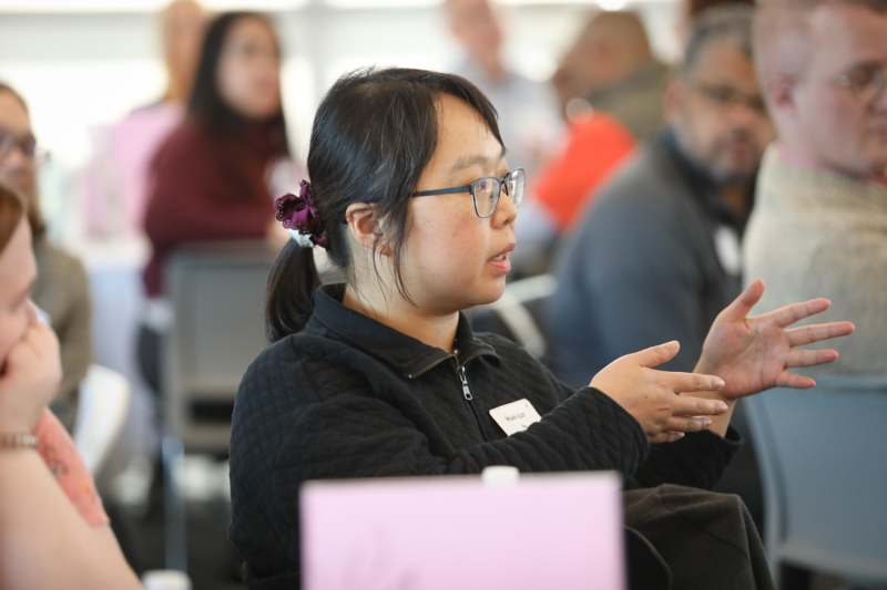 a woman in glasses clapping her hands