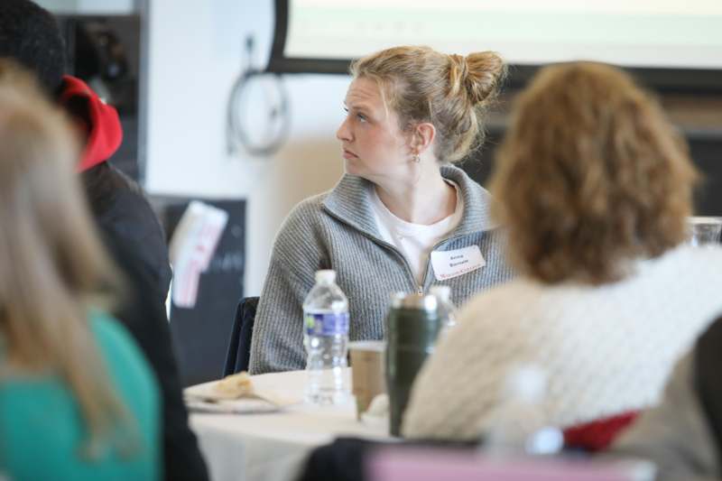 a woman sitting at a table with a man in a red hat