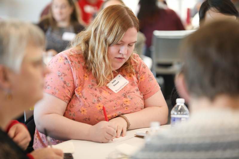 a woman writing on a piece of paper