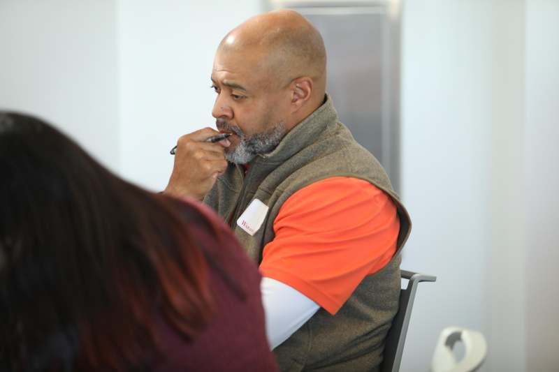 a man sitting in a chair with a pen in his mouth