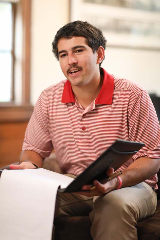 a man sitting on a couch holding a book