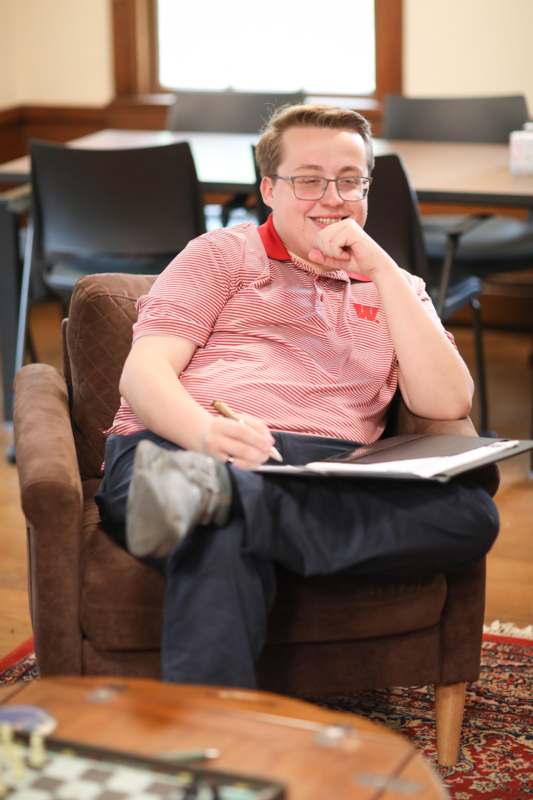 a man sitting in a chair holding a clipboard and pen