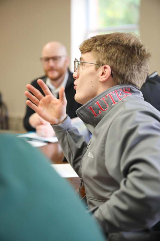 a man in a grey jacket with red text