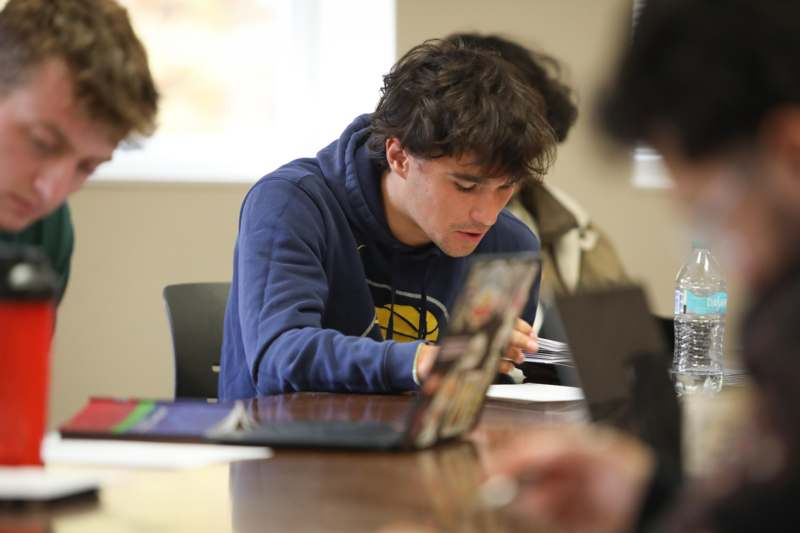 a man sitting at a table looking at a book