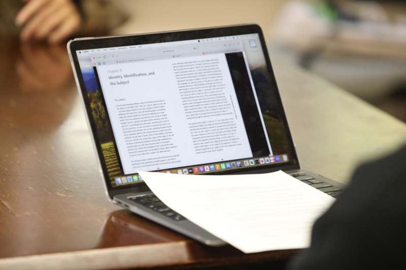 a person holding a paper on a laptop
