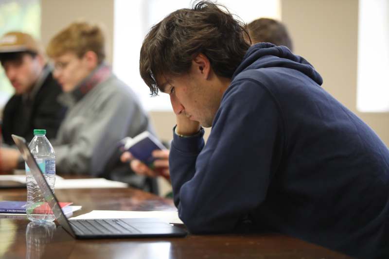 a man sitting at a table with a laptop