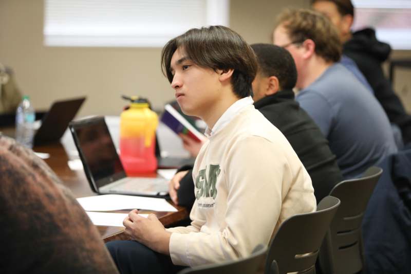 a man sitting in a room with a laptop