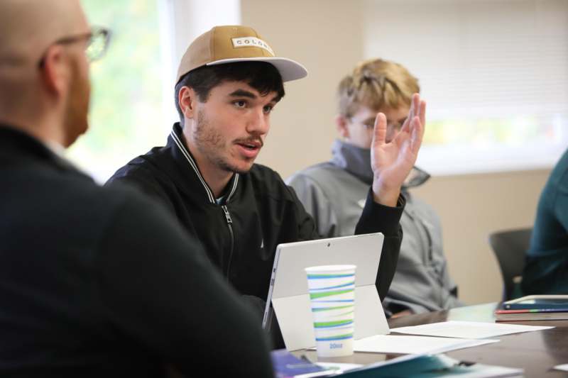 a man in a cap raising his hand