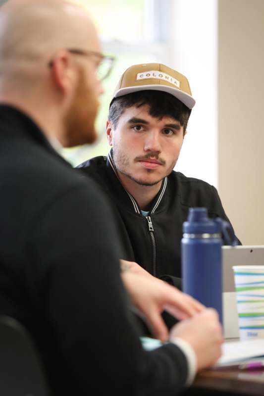 a man in a hat looking at another man