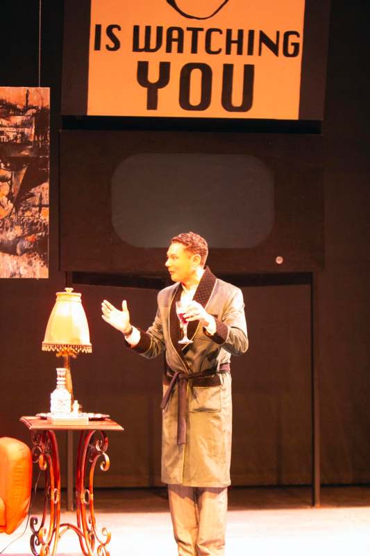 a man in a robe holding a glass of wine