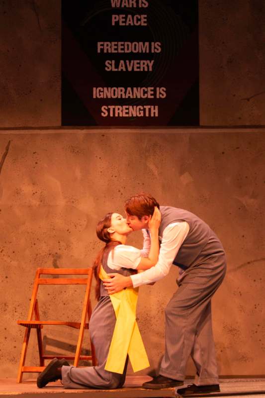 a man and woman kissing on stage