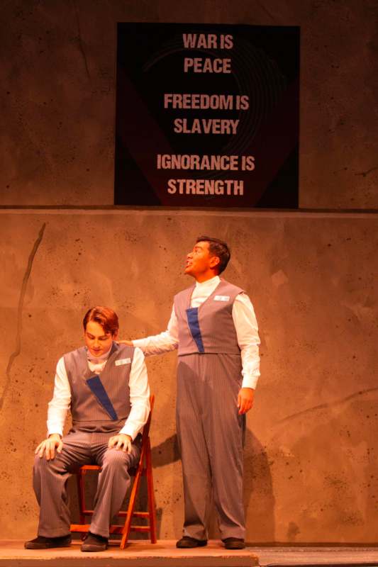 a man in overalls standing next to another man in overalls