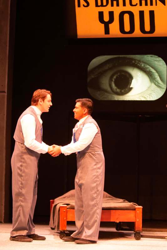 two men shaking hands on a stage