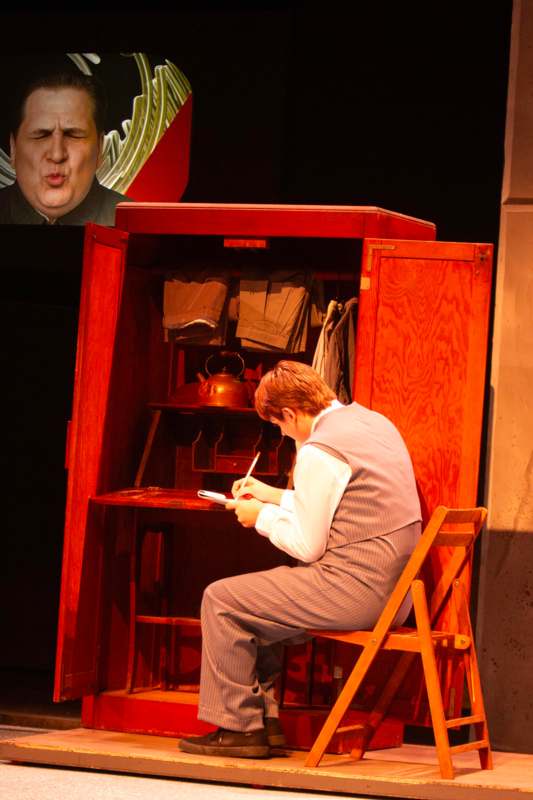 a man sitting on a chair writing on a book