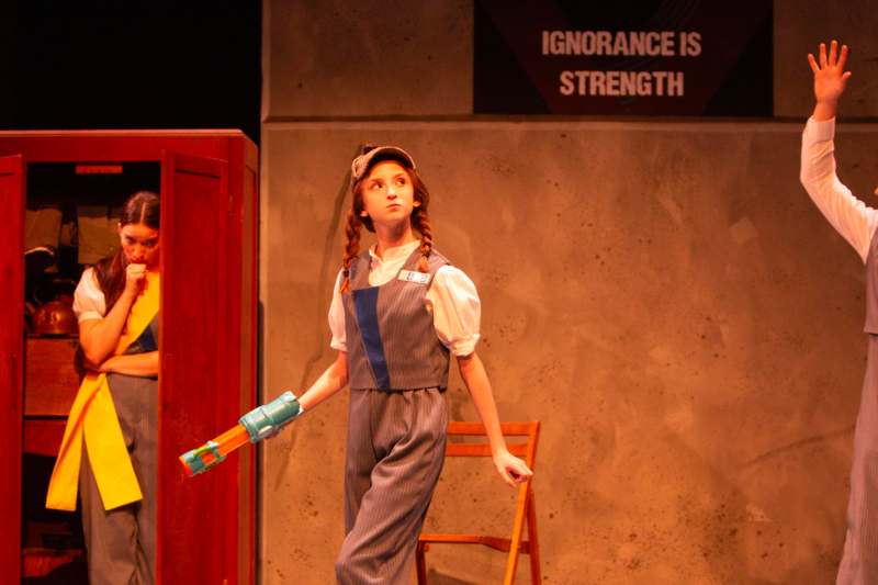 a girl in overalls holding a toy gun