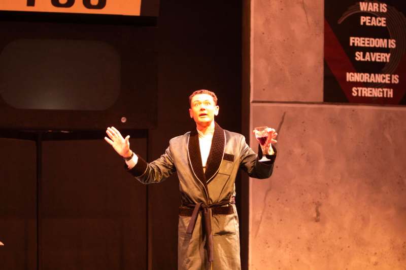 a man in a robe holding a glass of wine