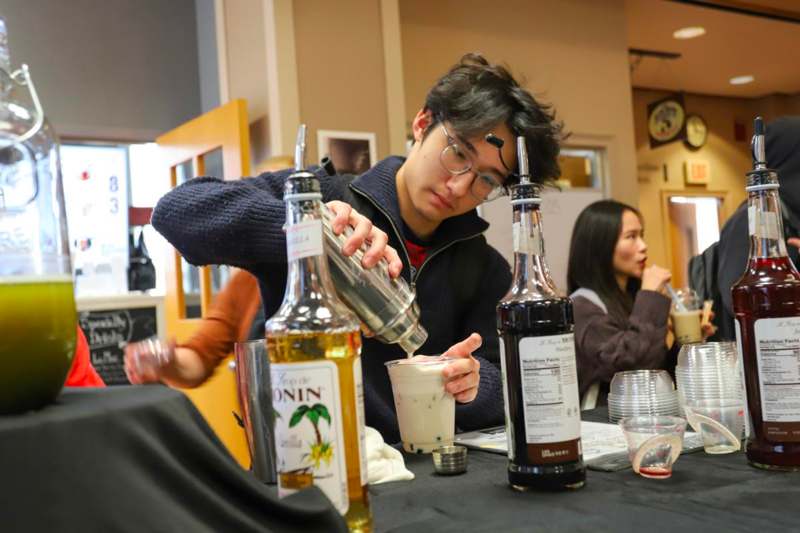 a man pouring a drink into a cup