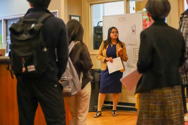 a woman standing in front of a whiteboard