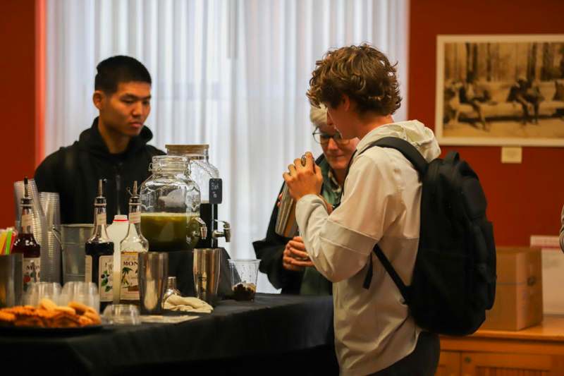 a group of people standing around a table with drinks