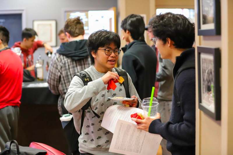 a man holding a piece of paper and a woman holding a drink