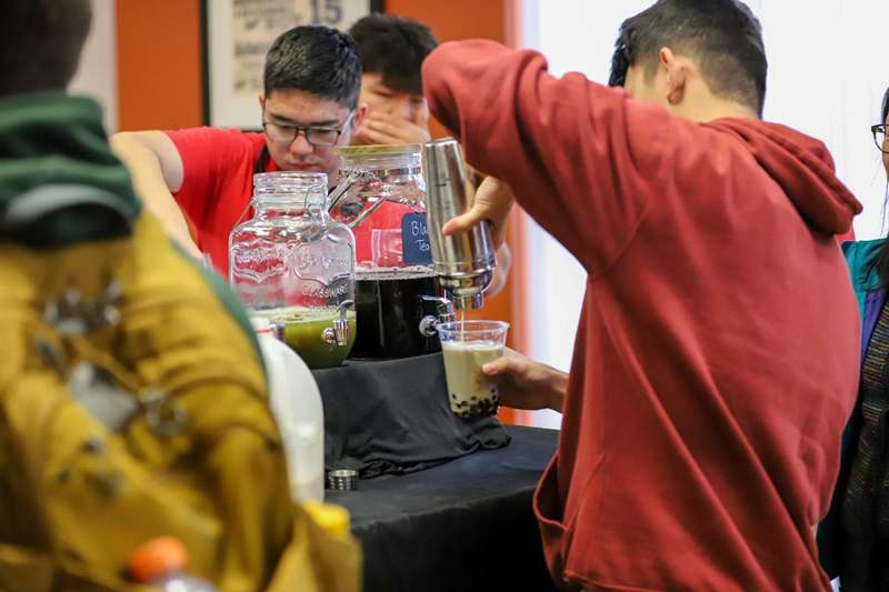 a group of people making drinks