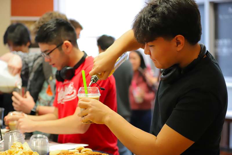 a man pouring a drink into a cup