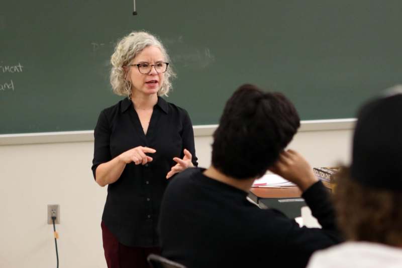 a woman standing in front of a chalkboard