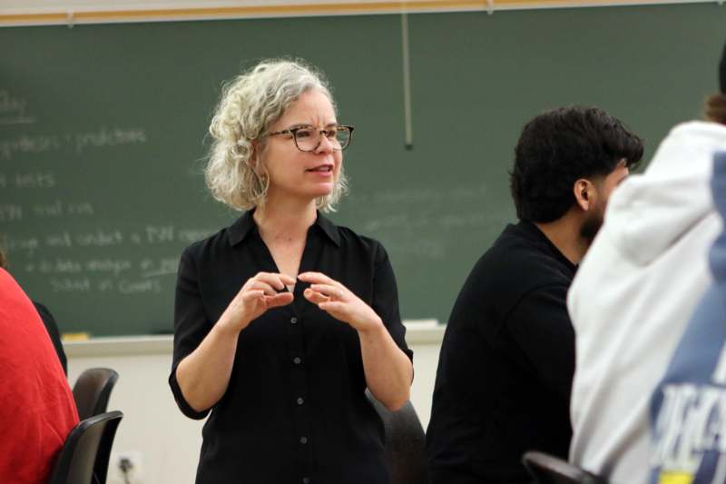 a woman standing in front of a chalkboard