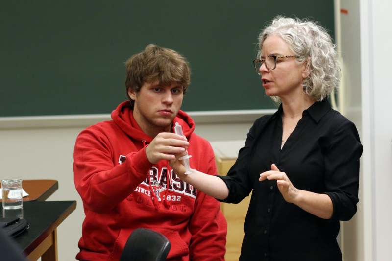 a woman giving a syringe to a man