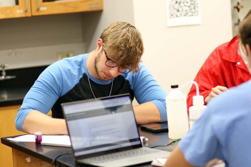 a man sitting at a table with a laptop
