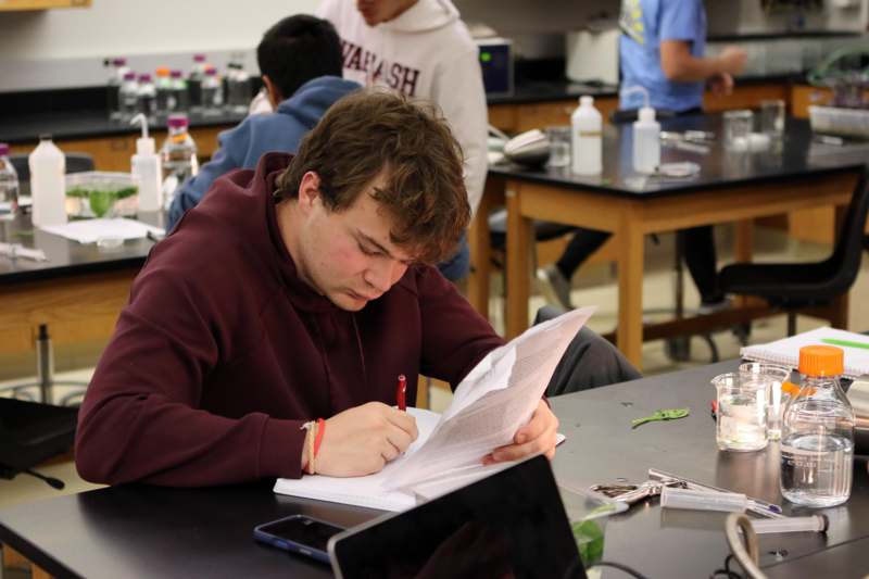 a man sitting at a table with a book and a pen
