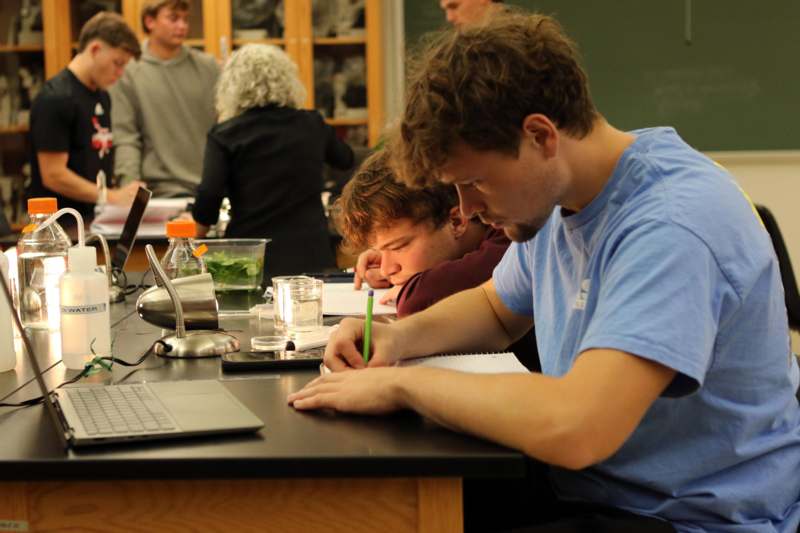 a group of people sitting at a table with a laptop