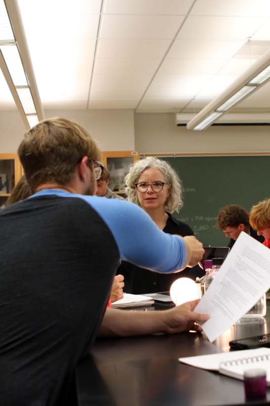 a woman pointing at a piece of paper