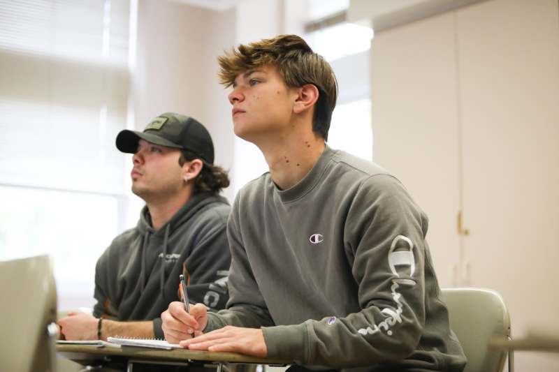 a man sitting at a desk with a pen and notebook