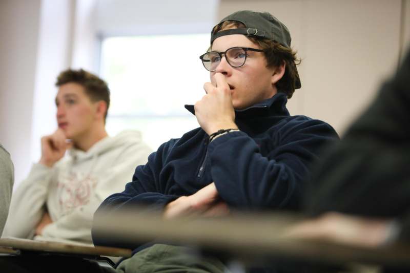 a man in a hat with his hand on his mouth