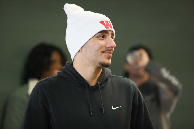 a man wearing a white beanie and black sweatshirt