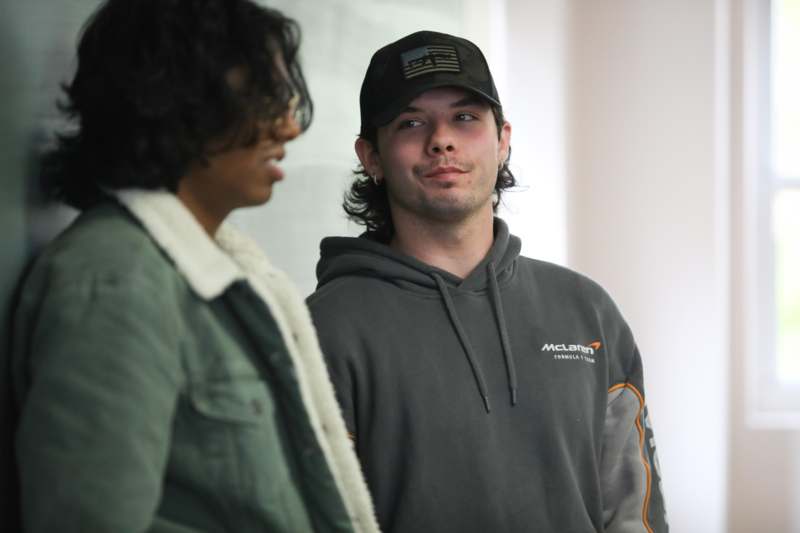 a man in a black hat and grey sweatshirt