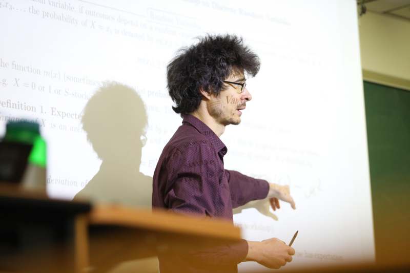 a man pointing at a white board