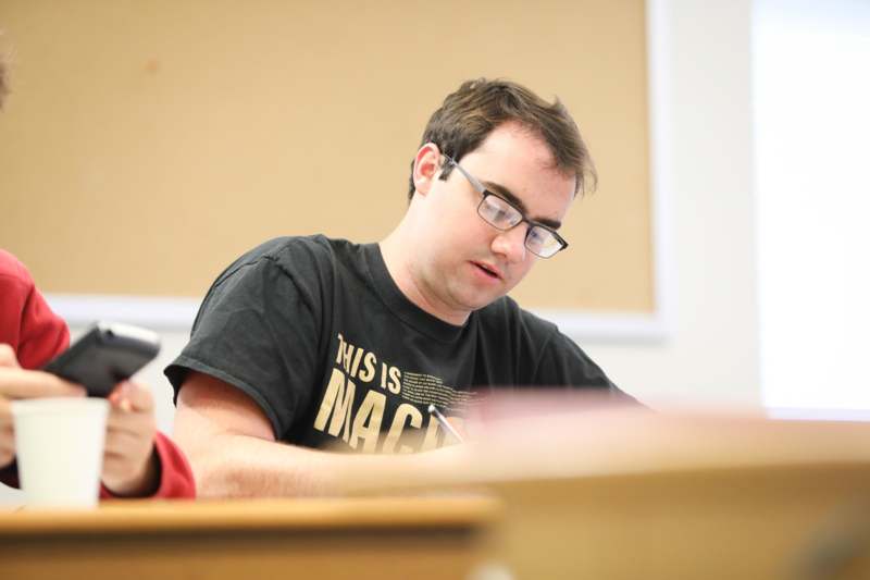 a man in glasses sitting at a desk