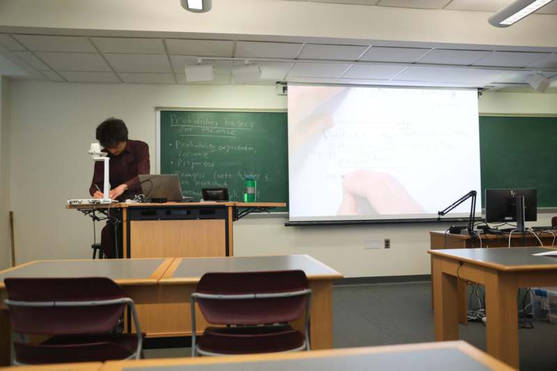a man sitting at a desk in front of a screen