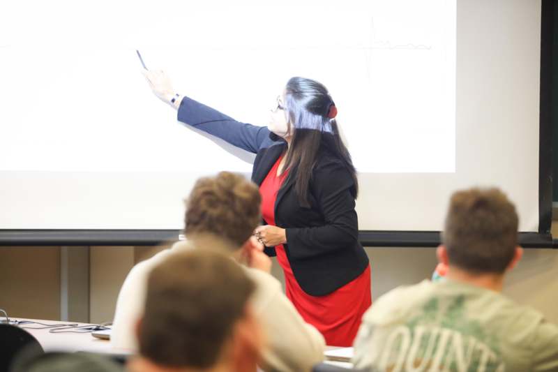 a woman pointing at a screen