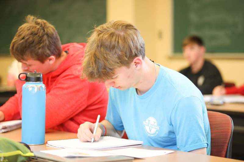 a man writing on a notebook