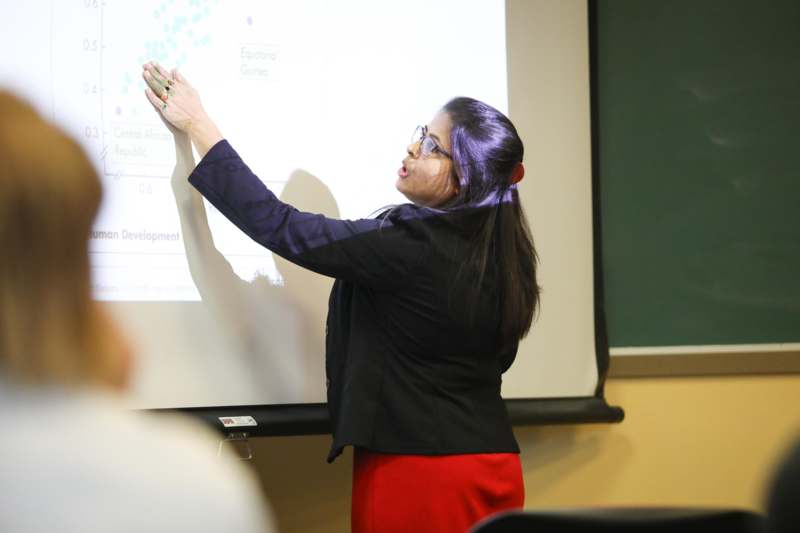 a woman standing in front of a white board