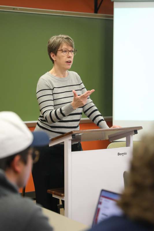 Classroom: RHE 350 with Professor Jennifer Abbott - a woman standing at a podium pointing at something