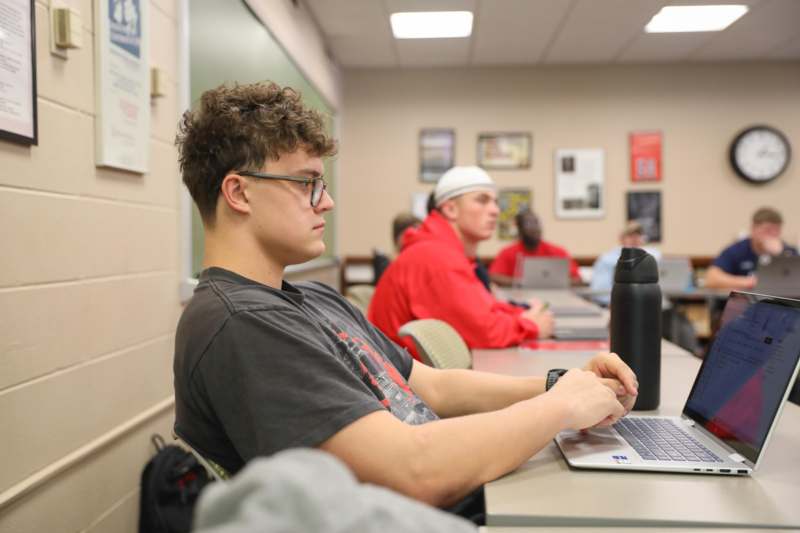 a man sitting at a table with a laptop