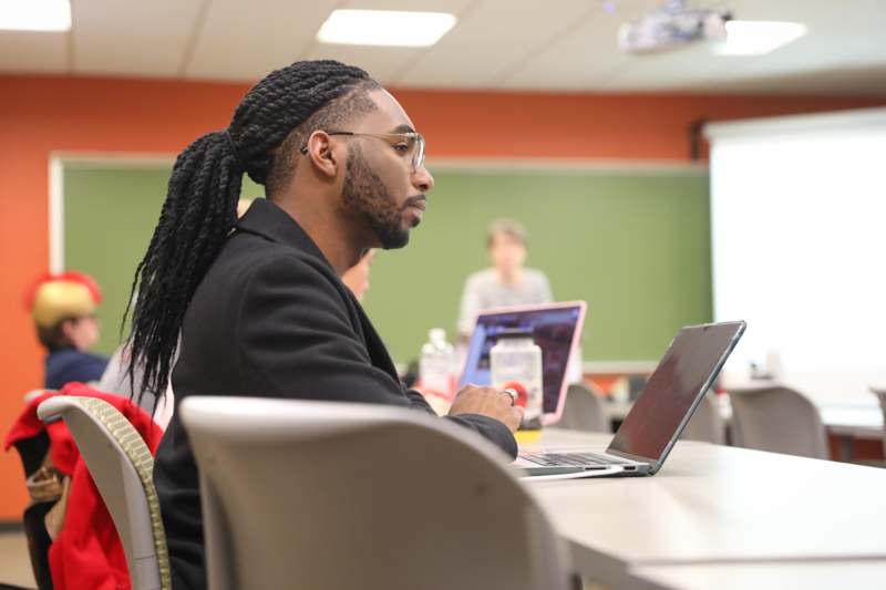 a man sitting at a table with a laptop