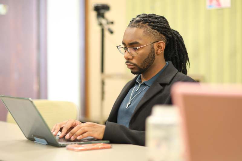 a man sitting at a table using a laptop