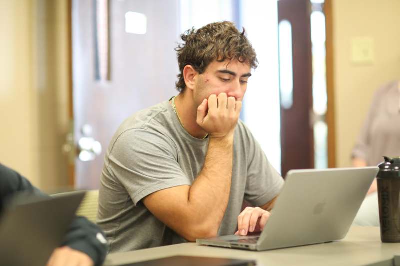 a man sitting at a table with his hand on his face