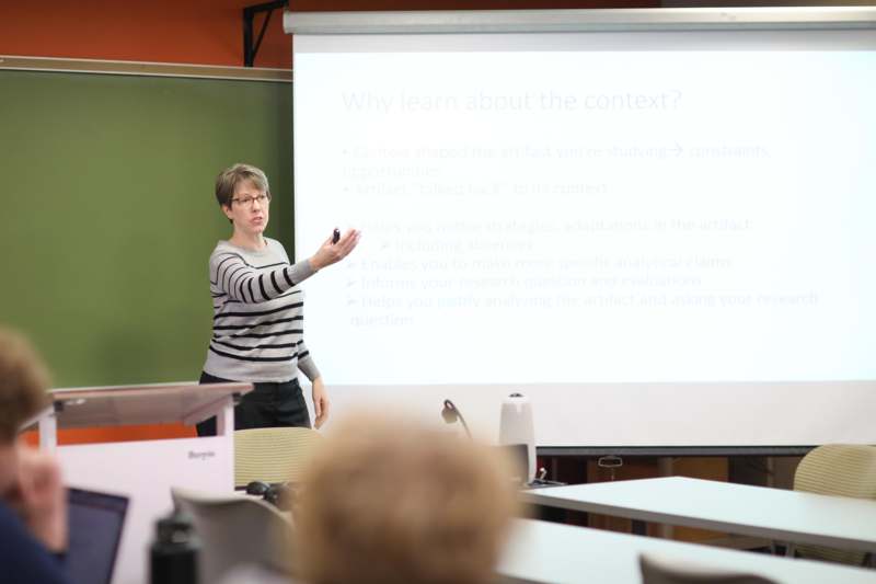 a woman standing in front of a white board