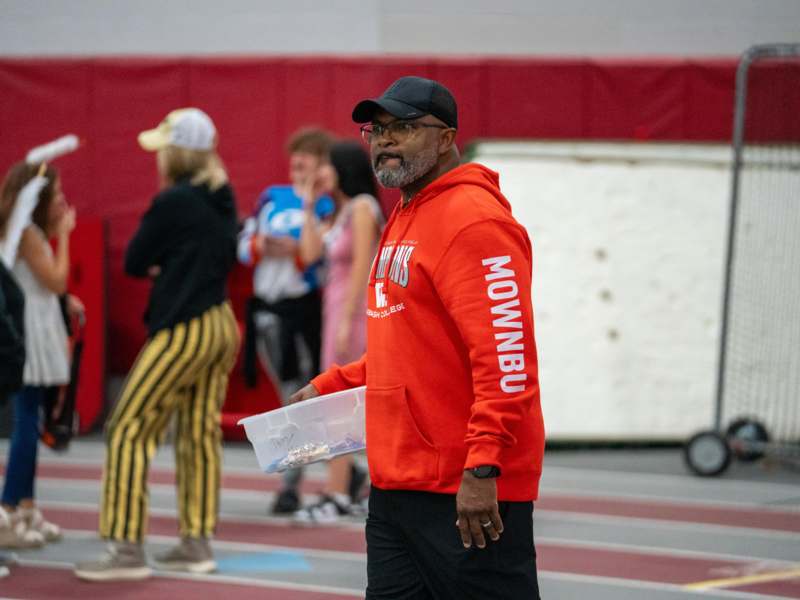 a man in a red hoodie holding a plastic container